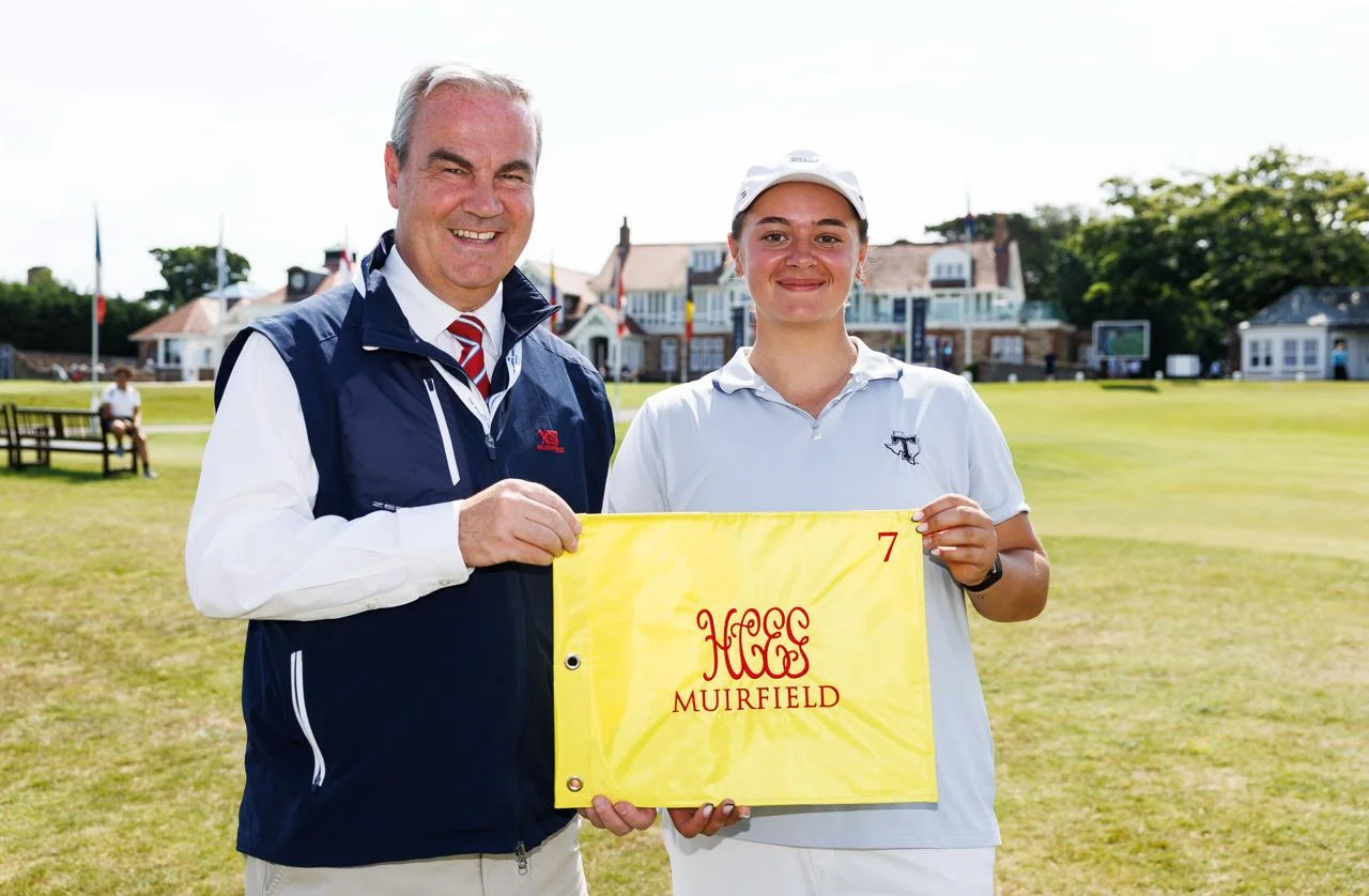 Louise Depadt is presented with a flag as a momento for her ace on the 7th hole at Muirfield.