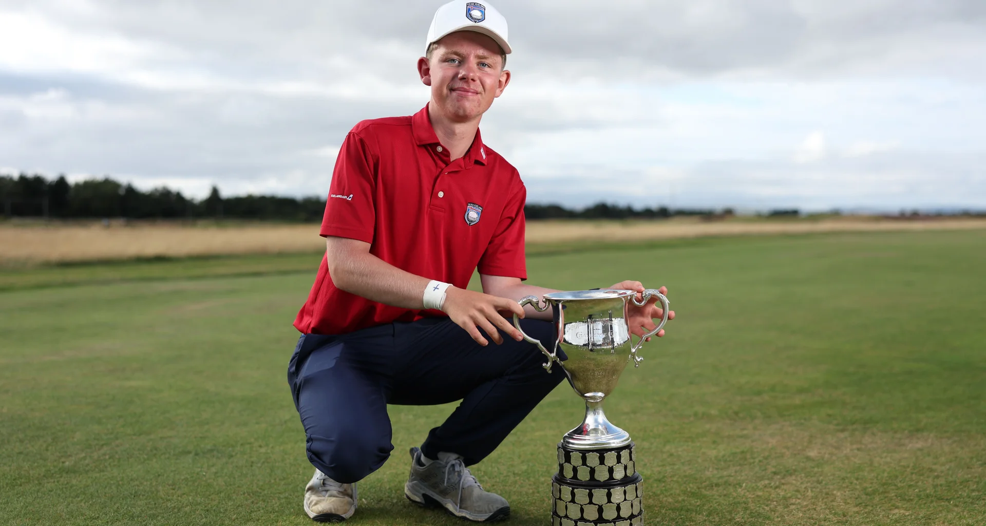 Oliver Eli Bjornsson celebrates with the Boys' Amateur Championship trophy.