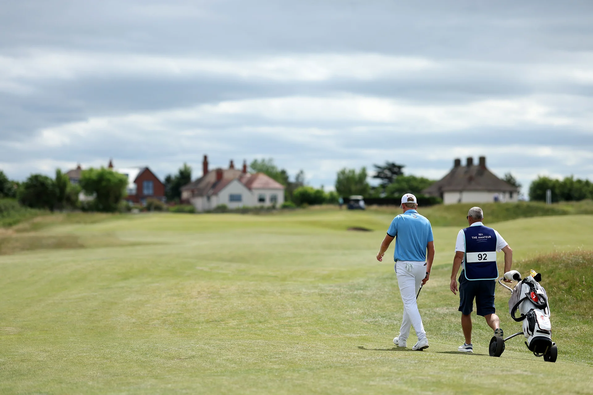 Luke Poulter of England walks with his caddie during Day Two of the 2026 Amateur Championship at Royal Liverpool Golf Club.
