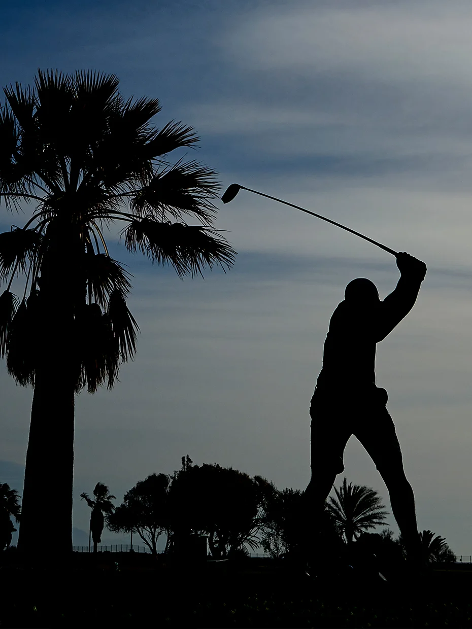 A golfer swings a club