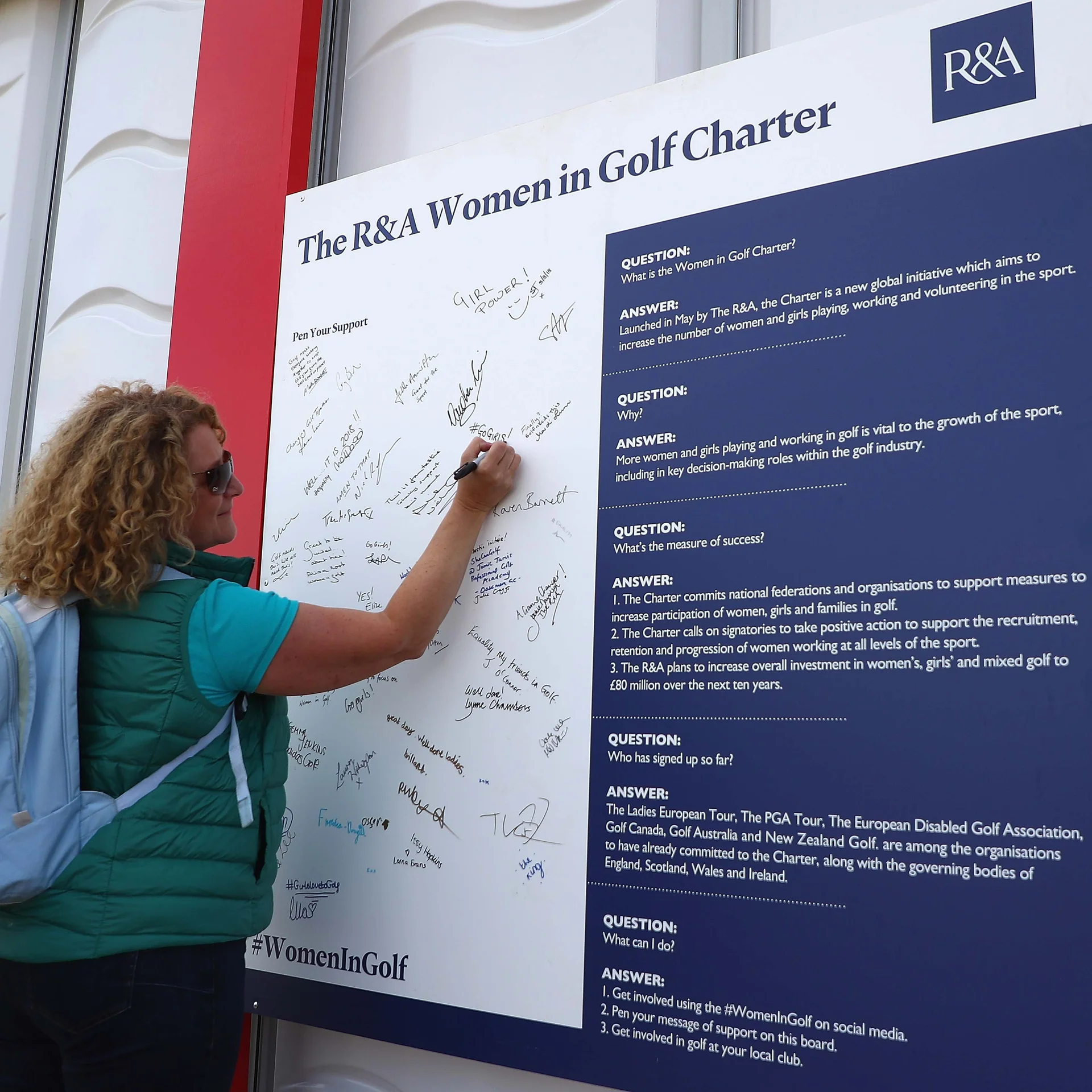 A woman signs The R&A Women in Golf Charter.