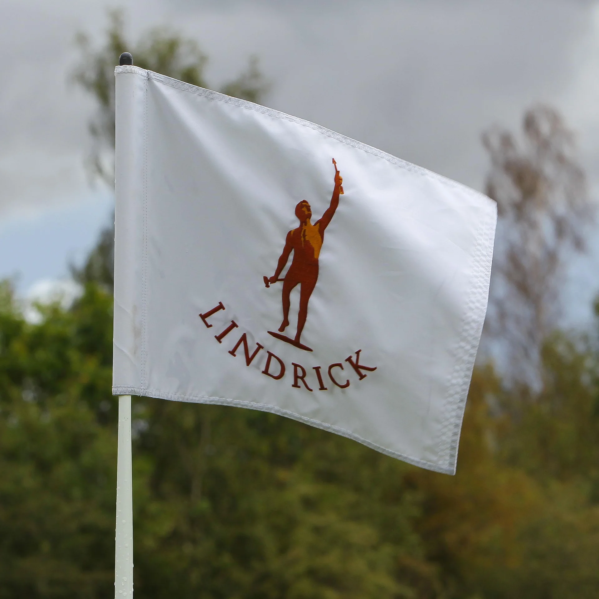 A white golf p[in flag with the Lindrick Golf Club logo.