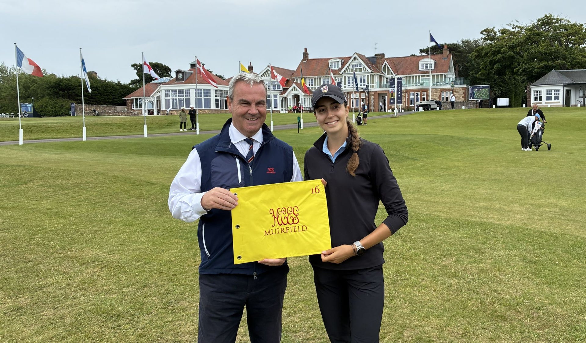 Vairana Heck of France is presented with a Muirfield flag by Secretary of the Honourable Company of Edinburgh Golfers Stuart McEwan after her hole in one