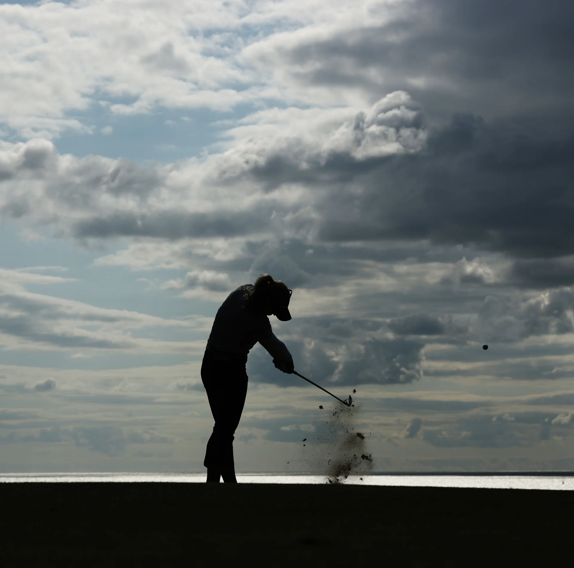 A silhouette of a person playing golf at Royal Porthcawl, Wales.