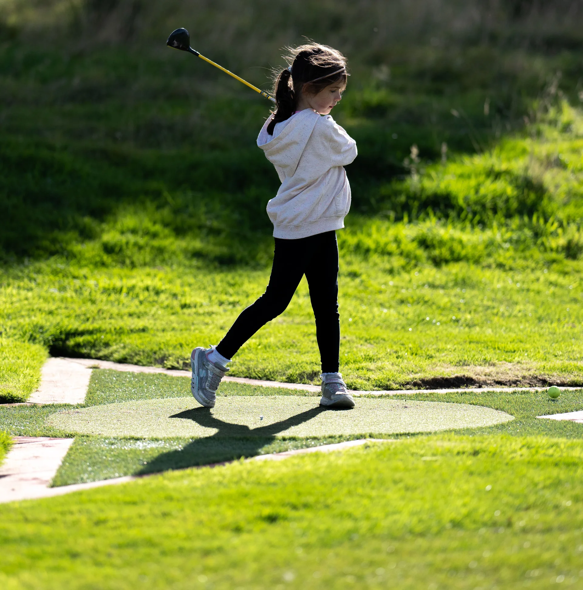 A young girl playing golf.