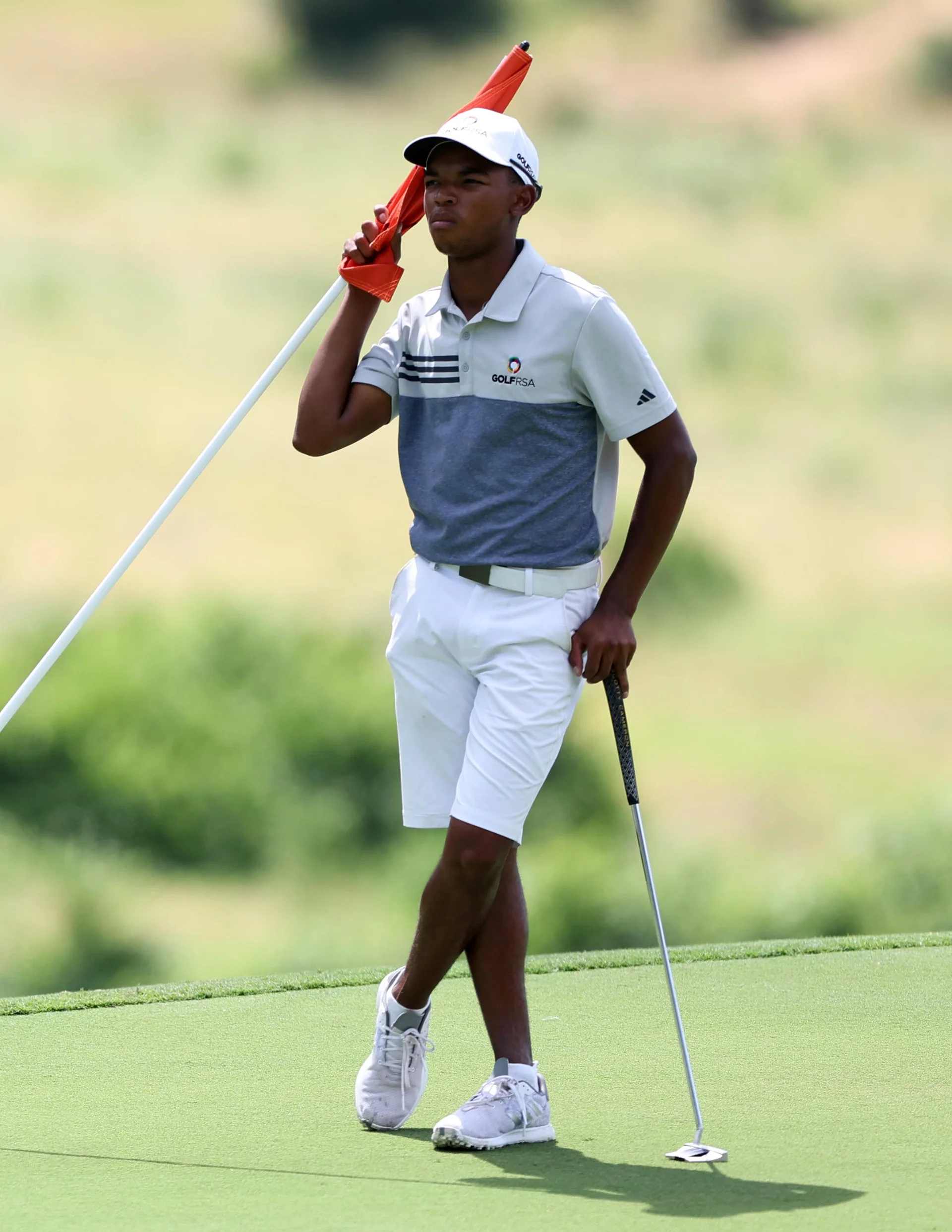 Johndre Ludick of South Africa holds on to a flag during of the Africa Amateur Championship at Leopard Creek Country Club.