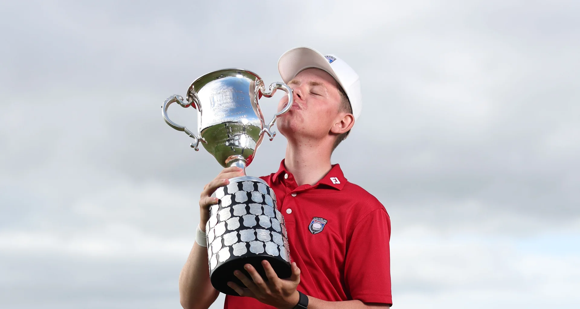Oliver Eli Bjornsson celebrates with the Boys' Amateur Championship trophy.