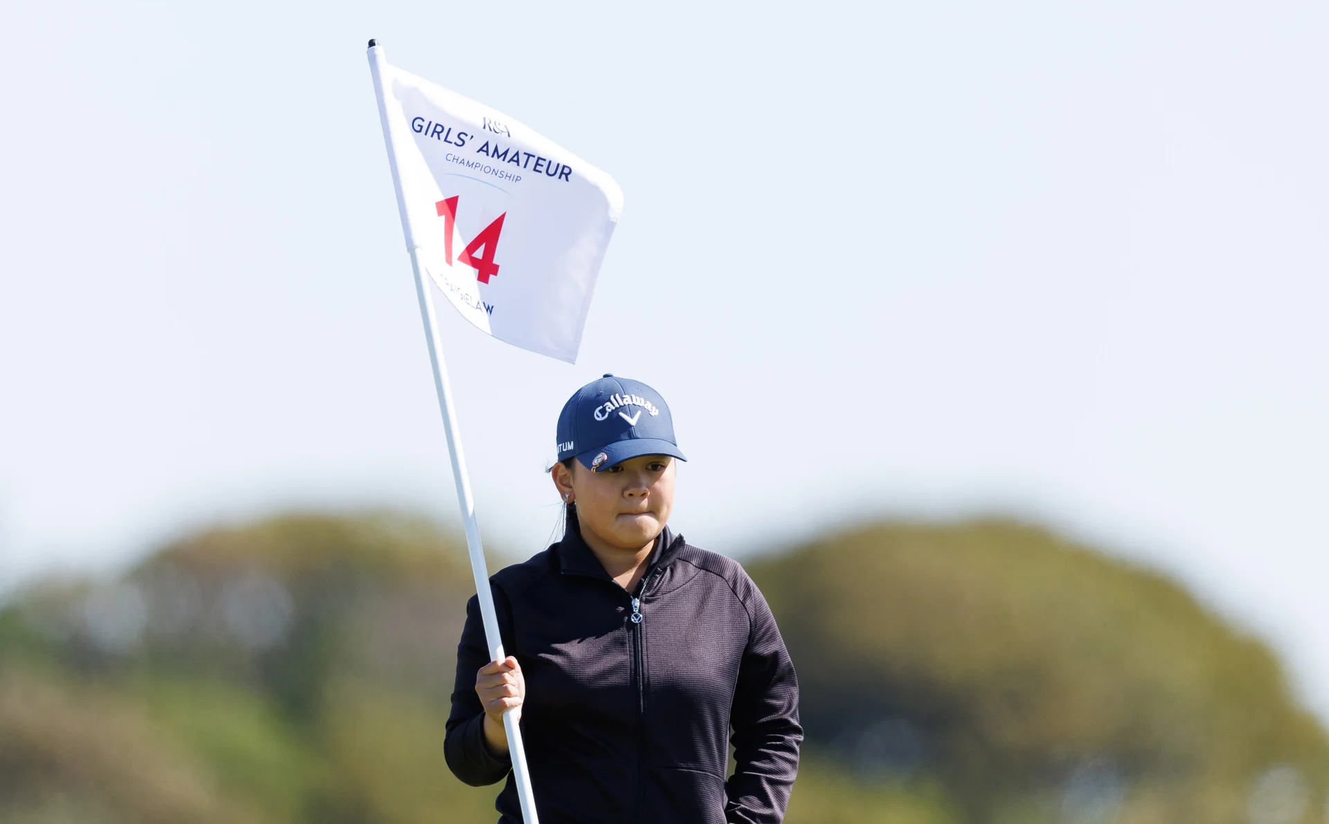 Sabrina Wong of Hong Kong, China replaces the flag at the 14th green during Day One of the R&A Girls' Amateur Championship.