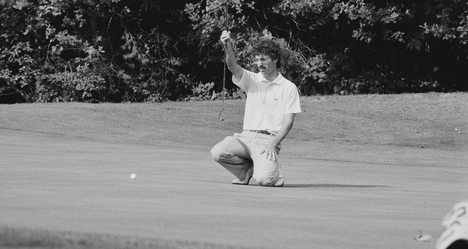 Golfer Corey Pavin lines up a putt on the green.