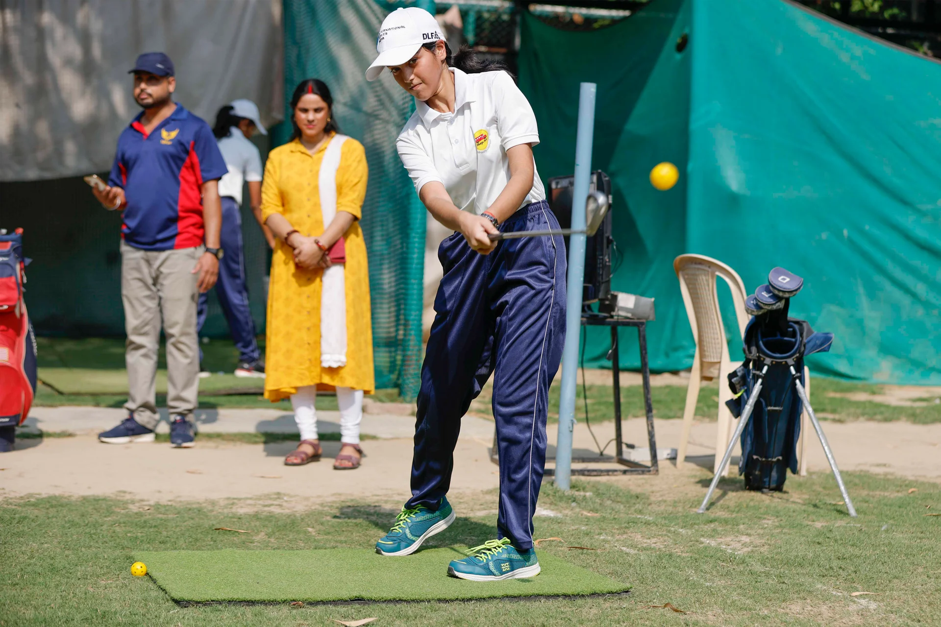 Manju watches on as her daughter Somi plays golf, a sport she says has transformed her daughter.