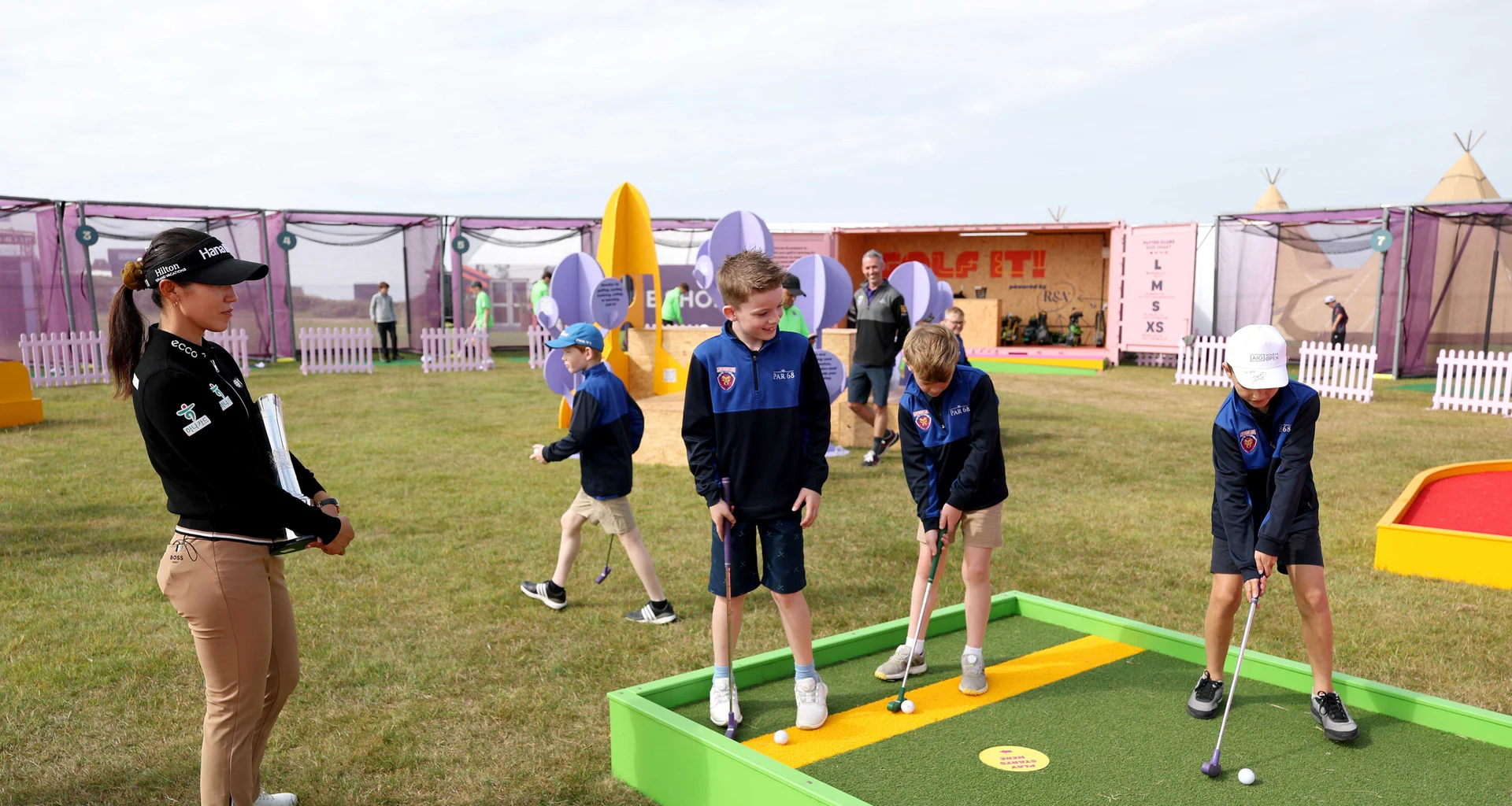 Lydia Ko of New Zealand watches on as children take part in the R&A 'Golf It' initiative prior to the AIG Women's Open 2025 at Royal Porthcawl Golf Club.