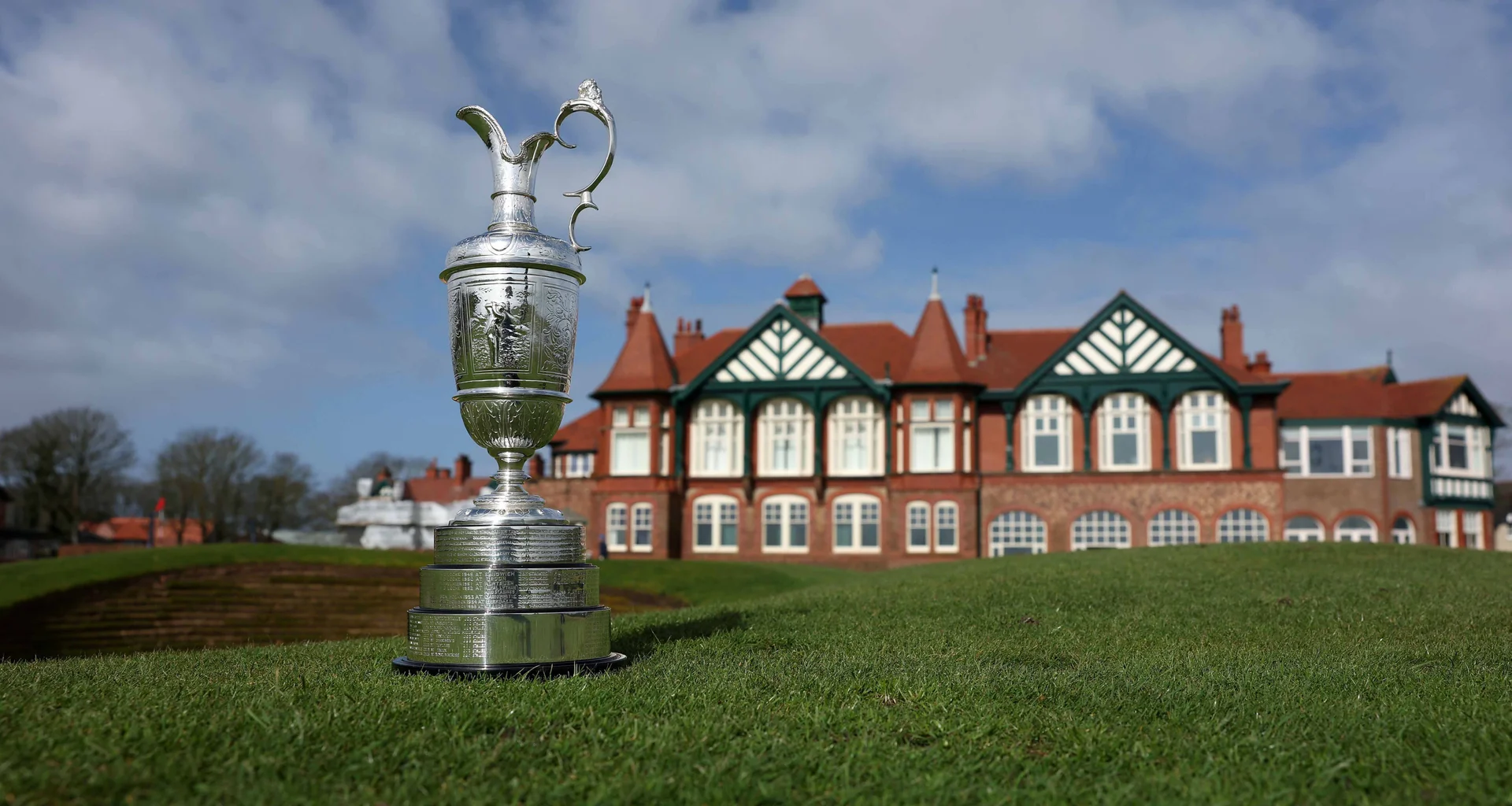 The Claret Jug stands on the grass in front of the Royal Lytham & St Annes clubhouse.
