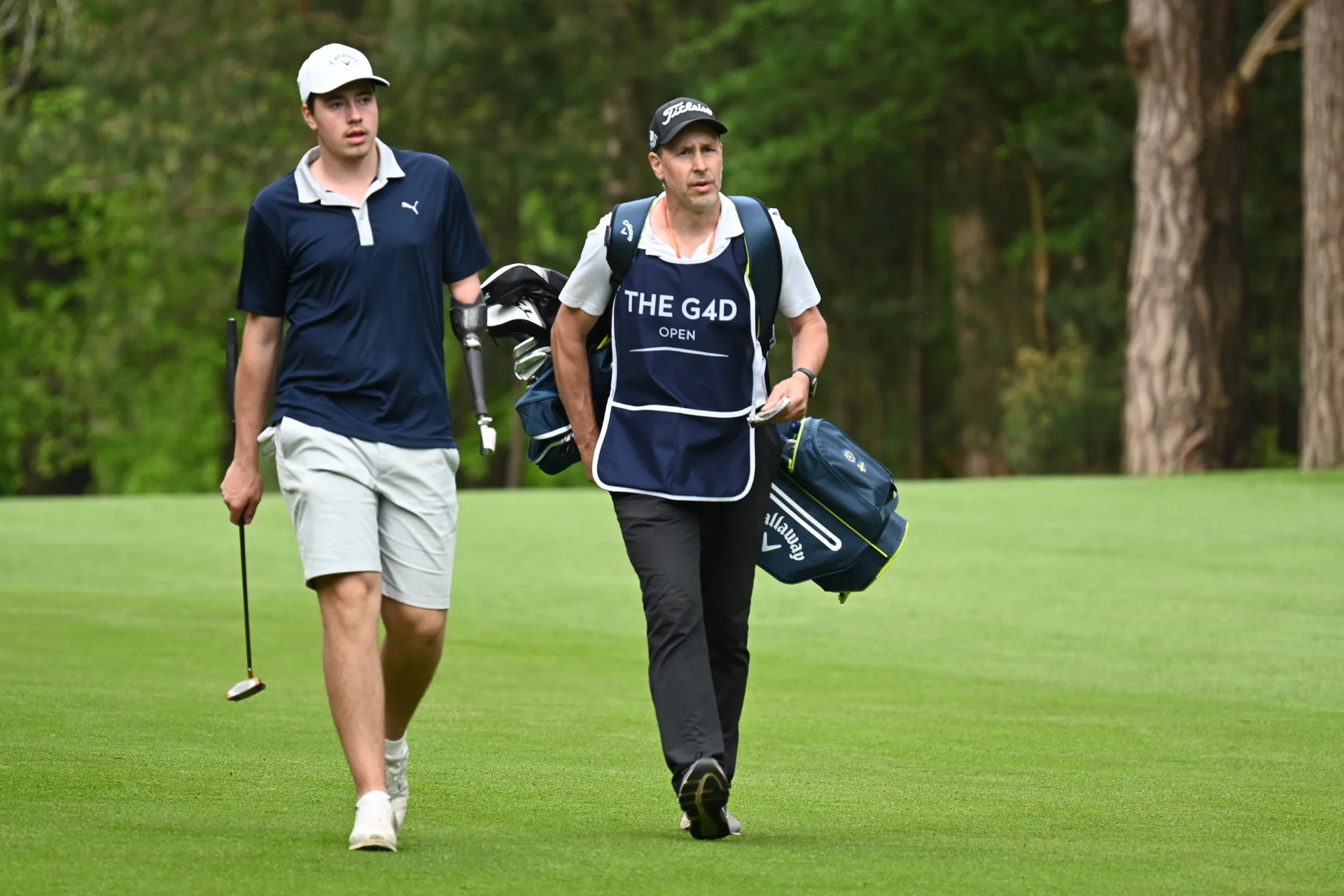Gustav Stigsson-Andersson walks down a fairway with his caddie by his side.