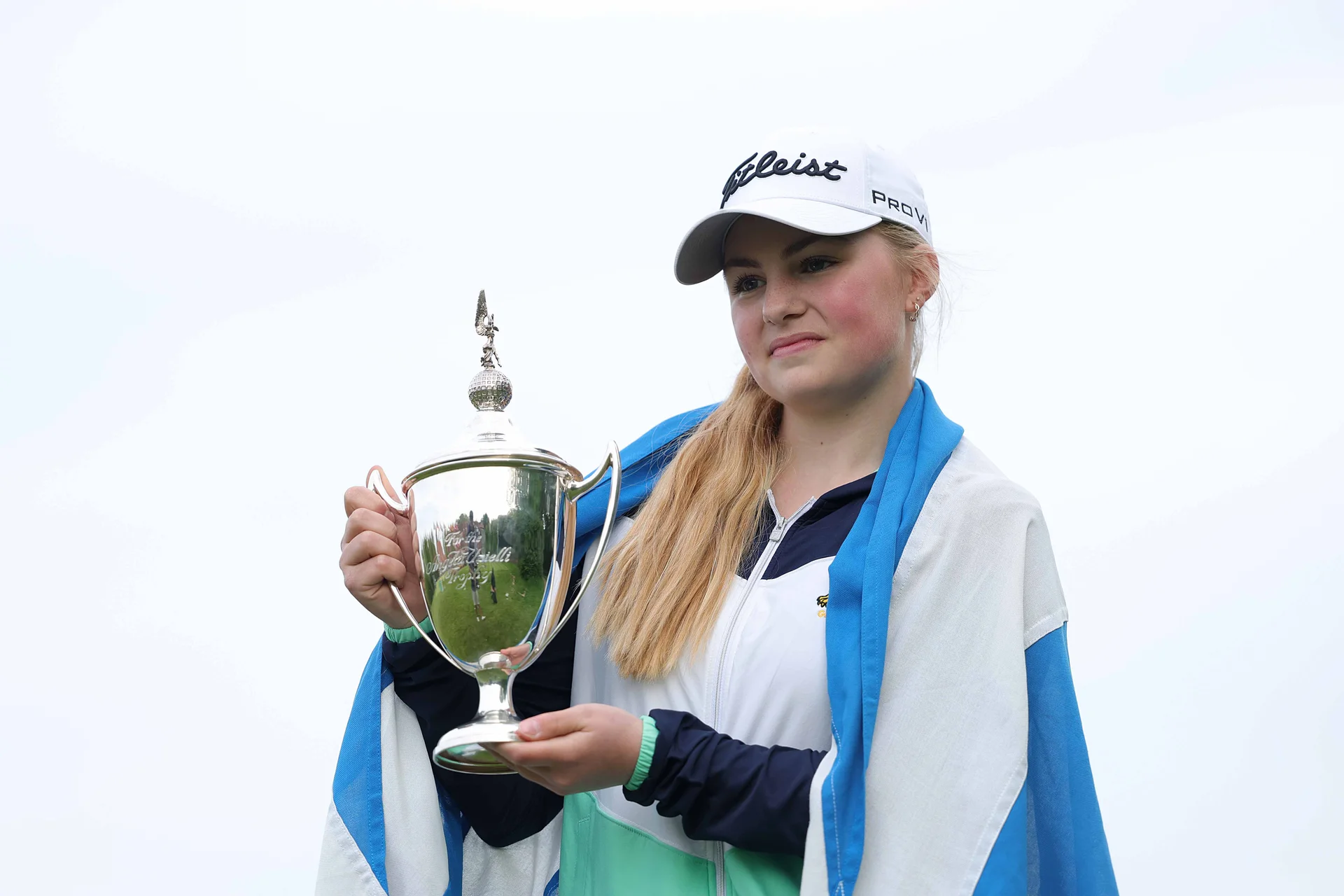Carly McDonald of St Regulus poses for a photo with the Angela Uzielli Trophy on the first hole during Day Three of the R&A Girls U16 Amateur Championship at Gog Magog Golf Club
