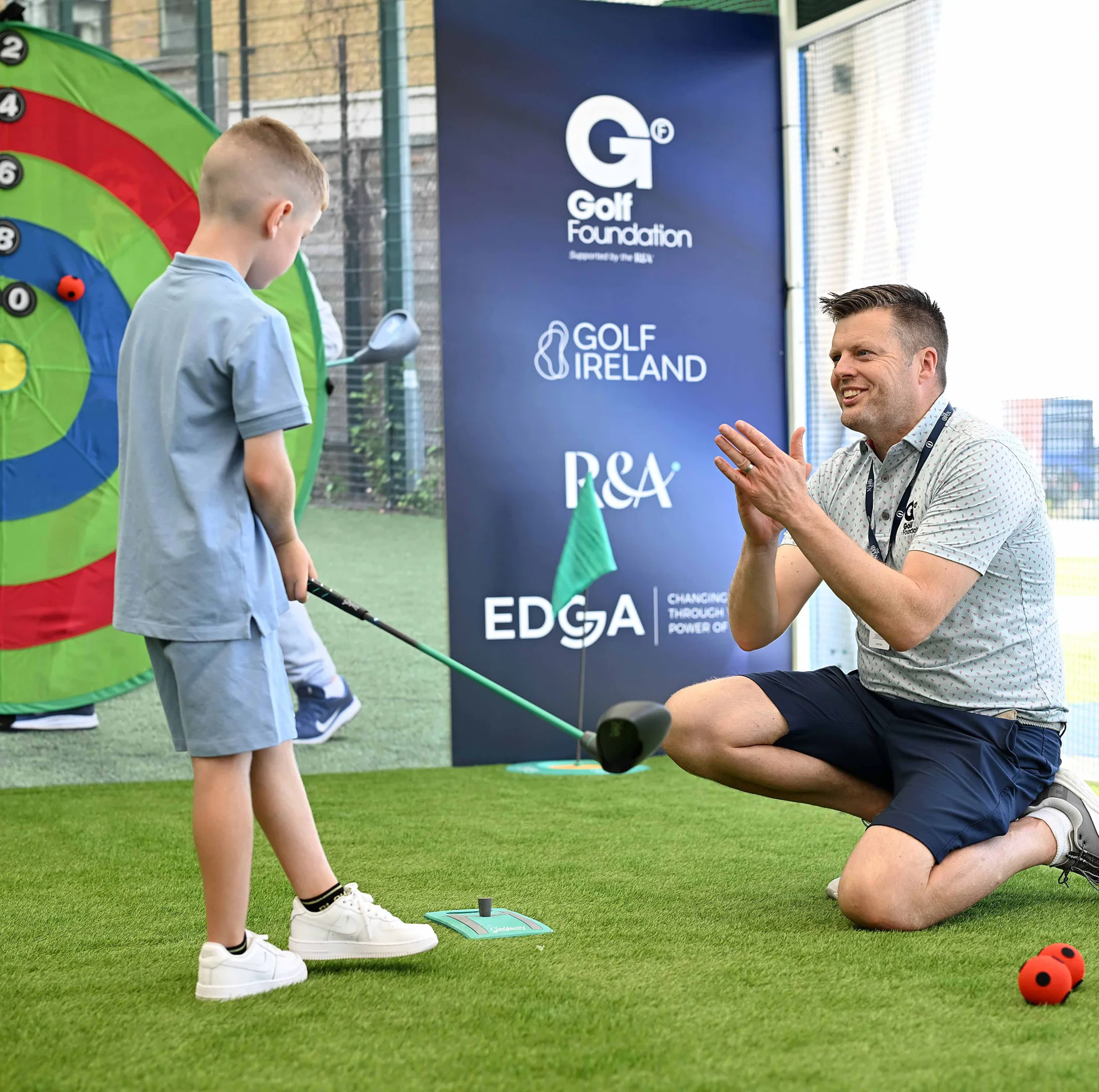 A golf coach provides advice and tips during a lesson with a young golfer.