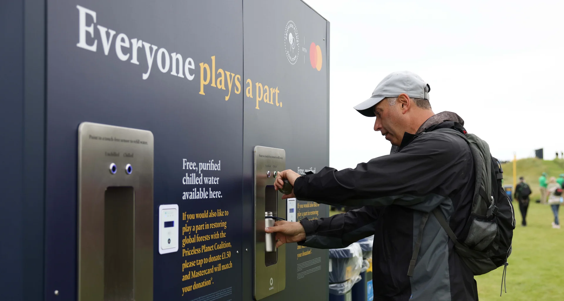 A man uses a refillable water bottle at The Open.