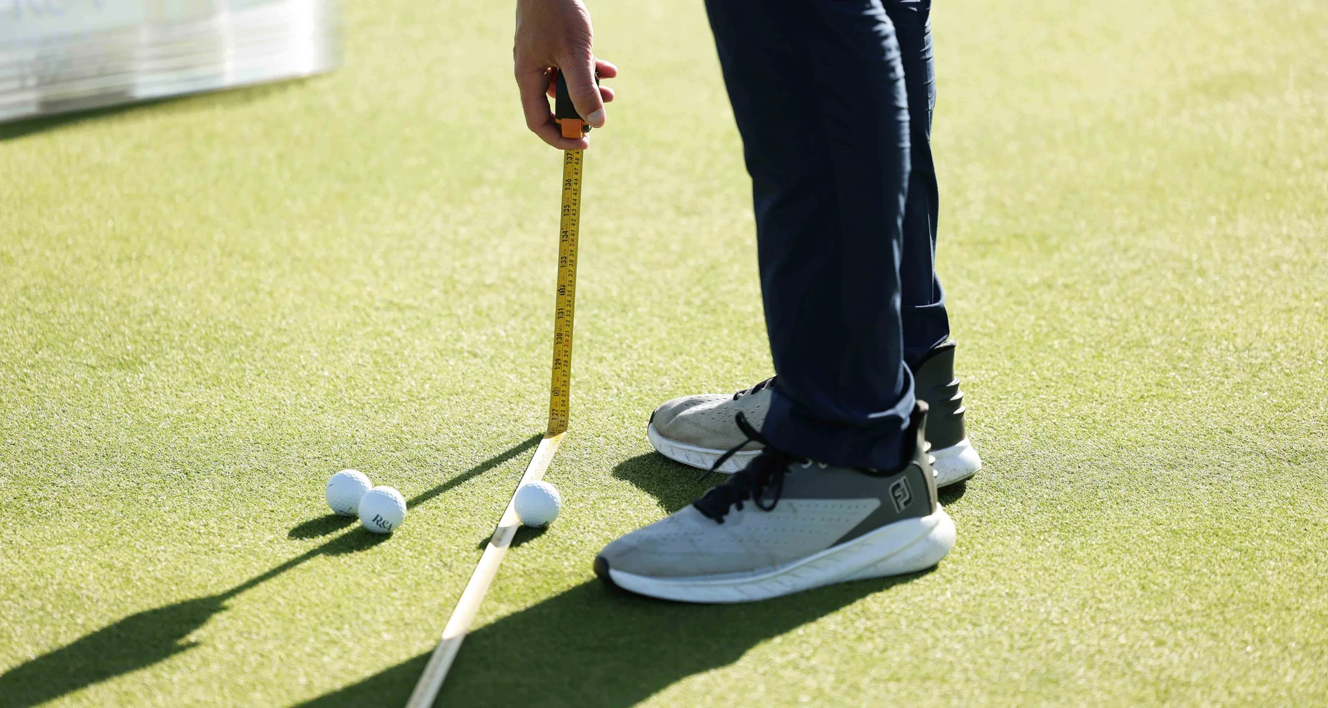 An agronomist from The R&A takes measurements on a golf green.