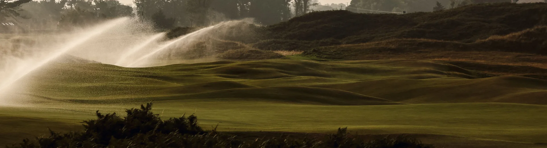 Sprinklers on over a golf course.