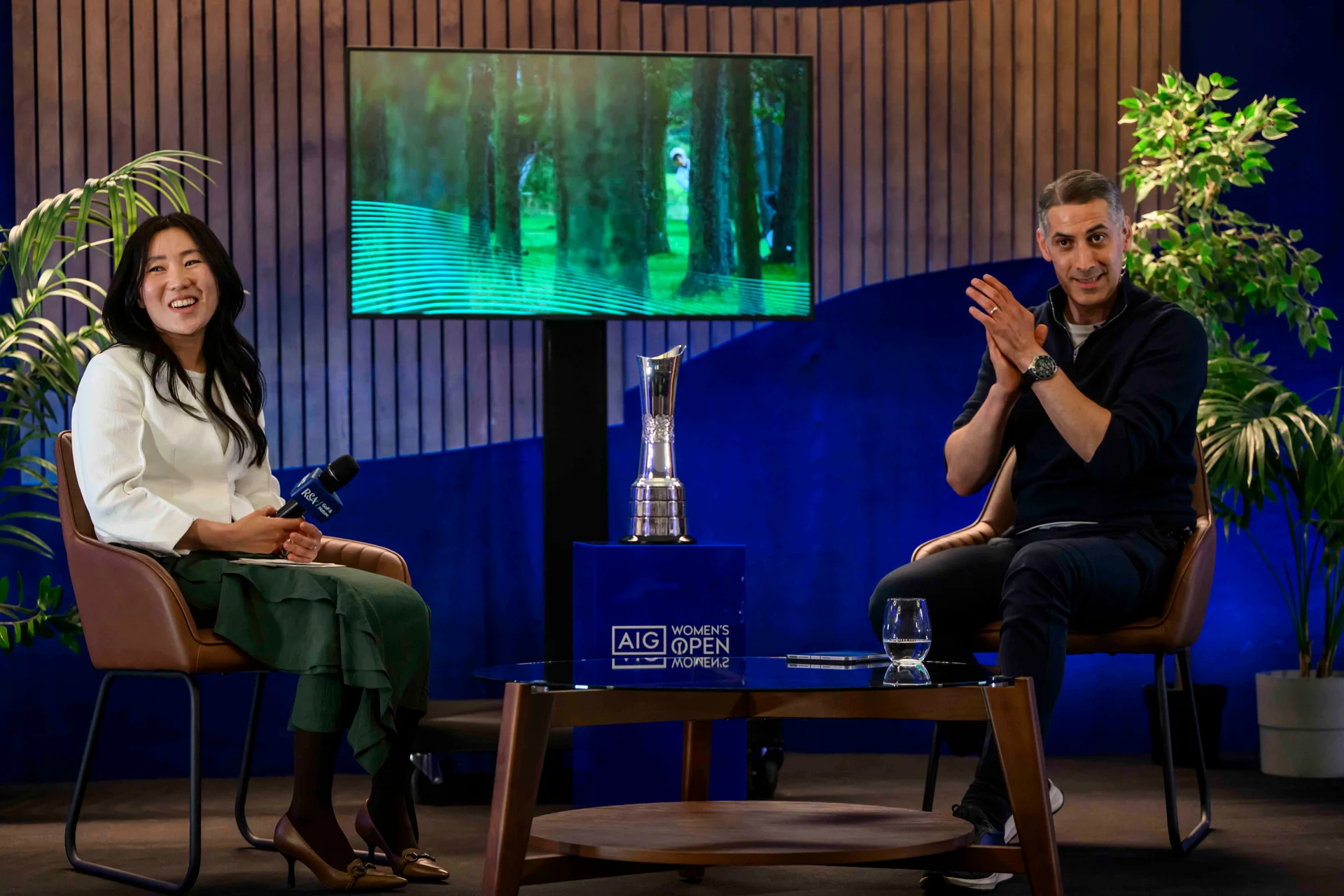 Former AIG Women’s Open champion I.K. Kim pictured alongside Golf & Nature live host David Garrido. They are pictured sitting opposite one another, in a casual setting, with the AIG Women's Open trophy in between them.